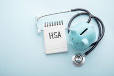 Health saving account, hsa concept, piggy bank with stethoscope on pastel blue background